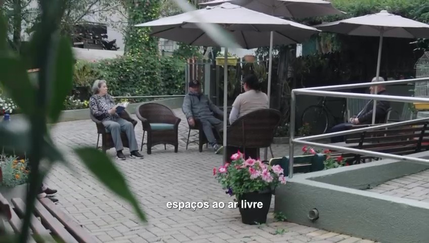 Área externa com jardim e espaço de convivência para idosos, representando bem-estar e rotina ao ar livre.